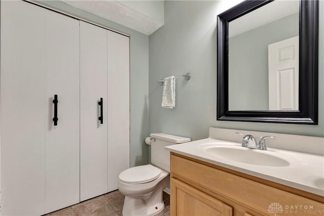 bathroom featuring tile patterned floors, toilet, and vanity