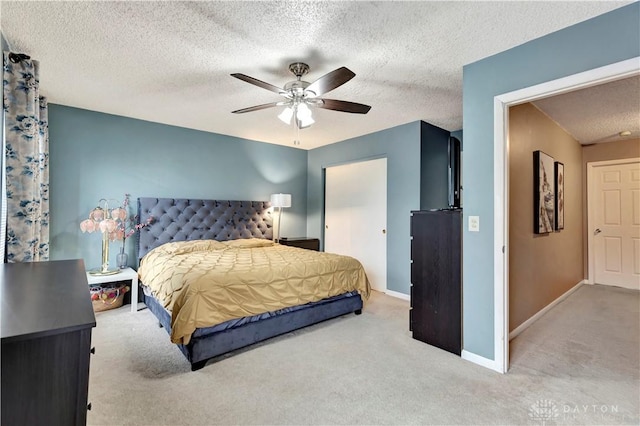 bedroom with a ceiling fan, baseboards, a textured ceiling, and carpet flooring