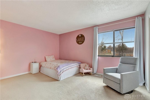 carpeted bedroom with visible vents, baseboards, and a textured ceiling