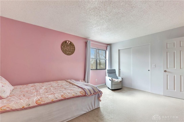 carpeted bedroom with a closet and a textured ceiling