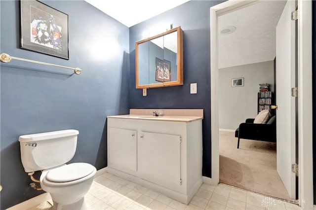 bathroom featuring baseboards, toilet, and vanity