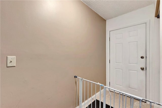 stairs with a textured ceiling