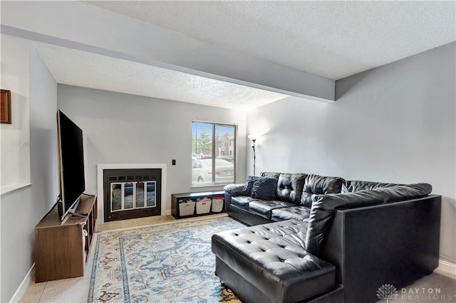 living room featuring a fireplace with flush hearth, a textured ceiling, and baseboards