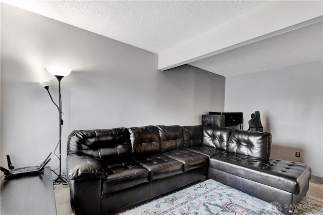 carpeted living room featuring beamed ceiling and a textured ceiling