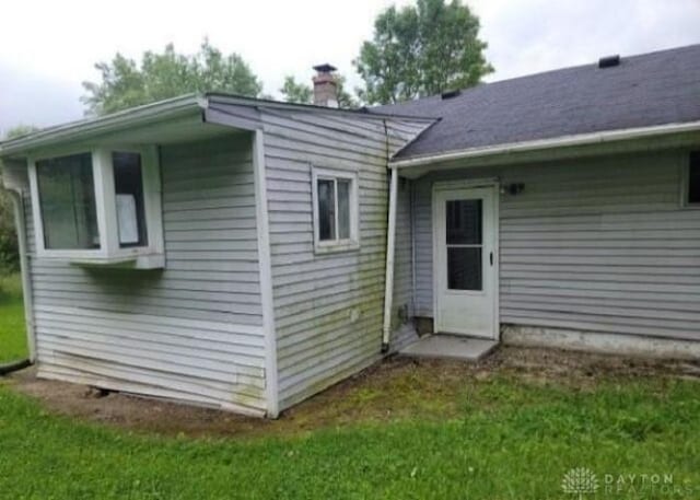 back of house with a chimney