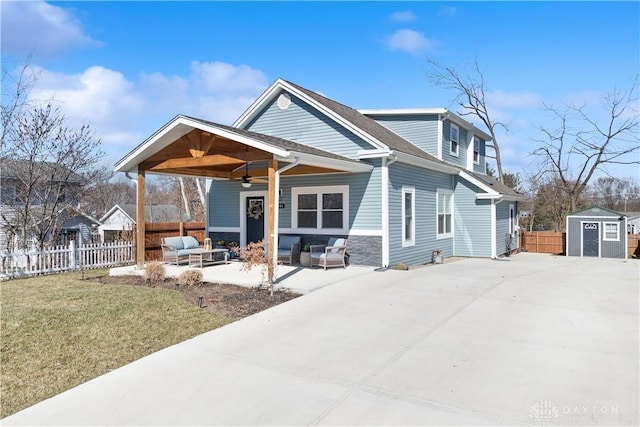 view of front of house with an outbuilding, fence, a storage shed, an outdoor hangout area, and ceiling fan