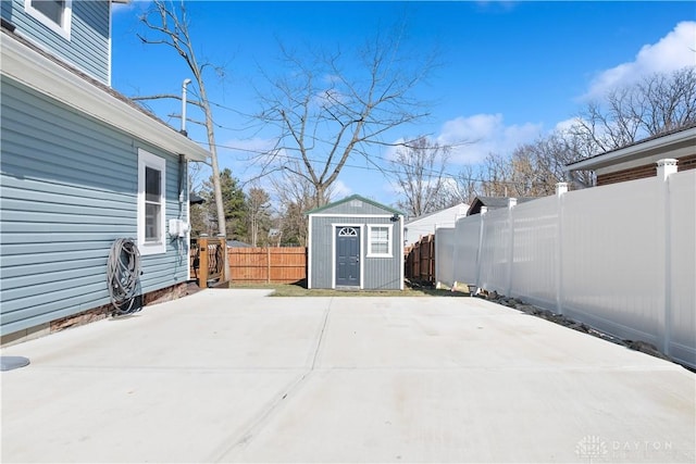 view of patio / terrace featuring a storage shed, a fenced backyard, and an outbuilding