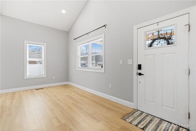 foyer with a wealth of natural light, visible vents, light wood-type flooring, and baseboards