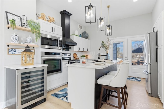 kitchen featuring visible vents, beverage cooler, a sink, appliances with stainless steel finishes, and light countertops