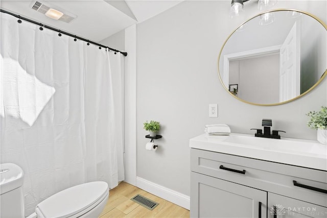 bathroom with visible vents, toilet, wood finished floors, and vanity