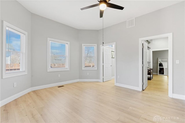 unfurnished room with a ceiling fan, visible vents, and light wood-type flooring