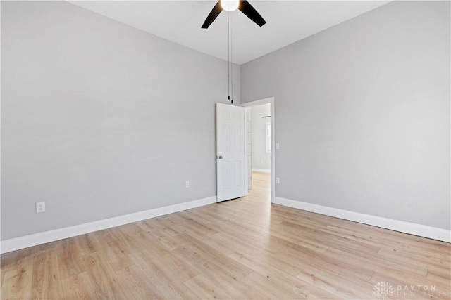 spare room featuring light wood finished floors, ceiling fan, and baseboards