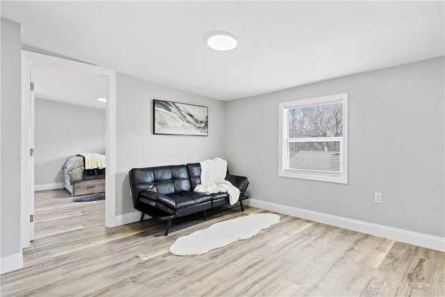 sitting room with baseboards and wood finished floors