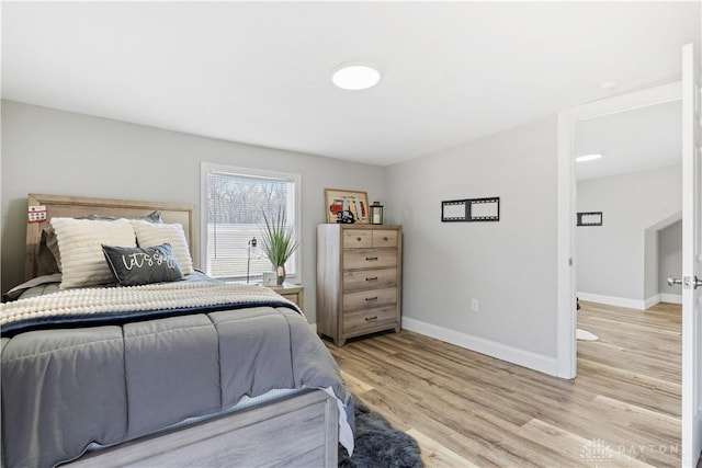 bedroom featuring baseboards and light wood finished floors