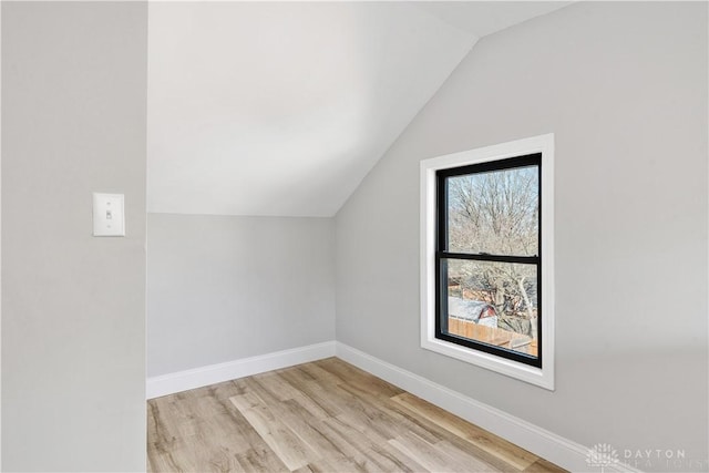 bonus room featuring baseboards, light wood-style flooring, and vaulted ceiling