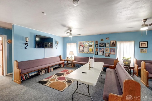 living area with a healthy amount of sunlight, ceiling fan, and carpet floors