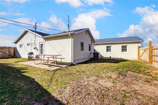 rear view of house featuring a fenced backyard, a yard, and a patio