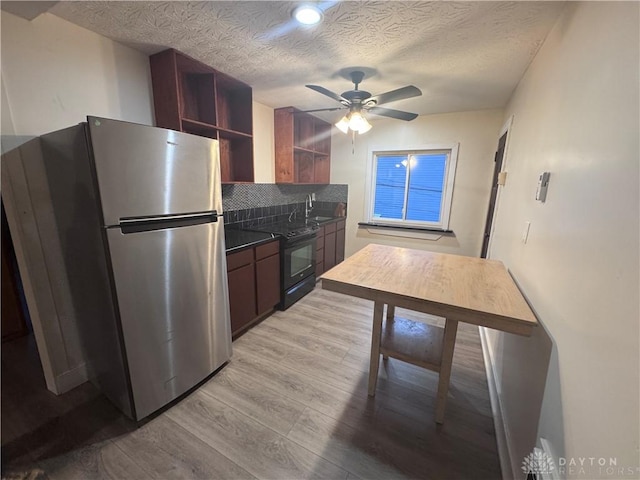 kitchen with black / electric stove, light wood finished floors, open shelves, freestanding refrigerator, and dark countertops