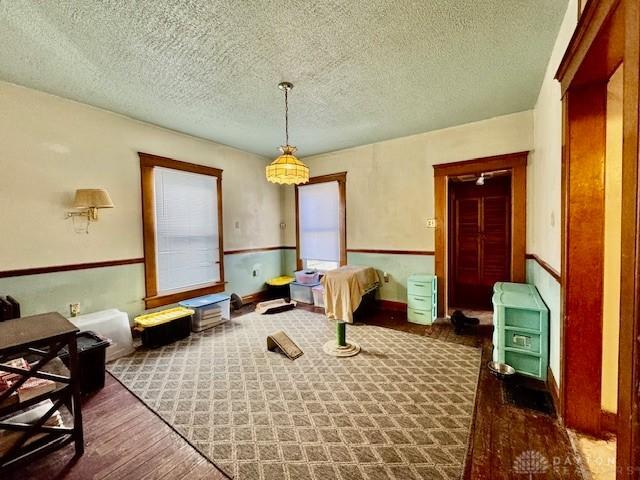 dining room with wood finished floors and a textured ceiling