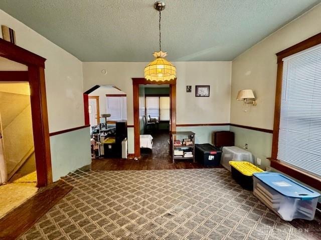 interior space with arched walkways and a textured ceiling