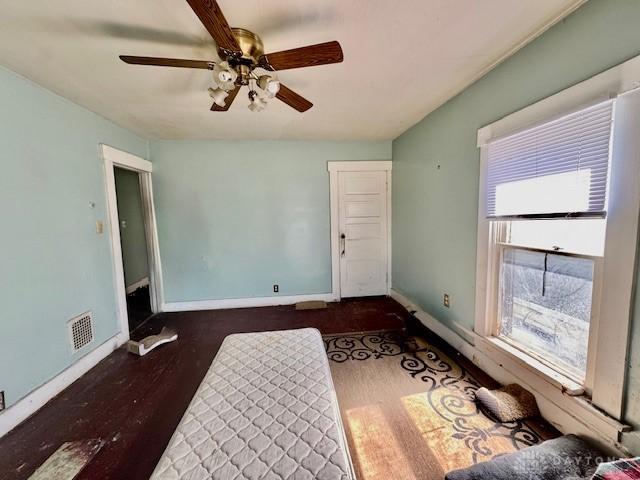 unfurnished living room featuring visible vents, baseboards, and wood finished floors