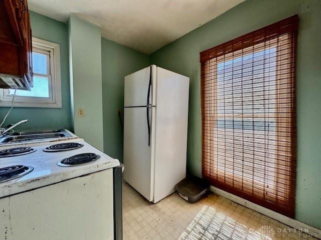 kitchen with a sink, white appliances, and light floors