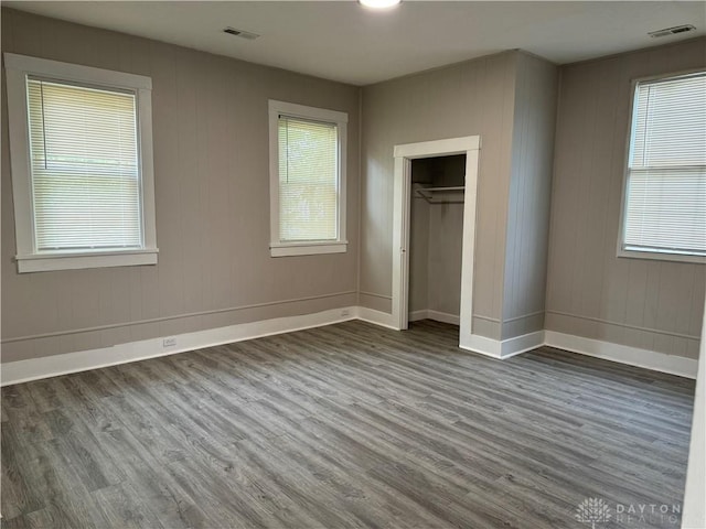 unfurnished bedroom with visible vents, baseboards, and dark wood-style flooring