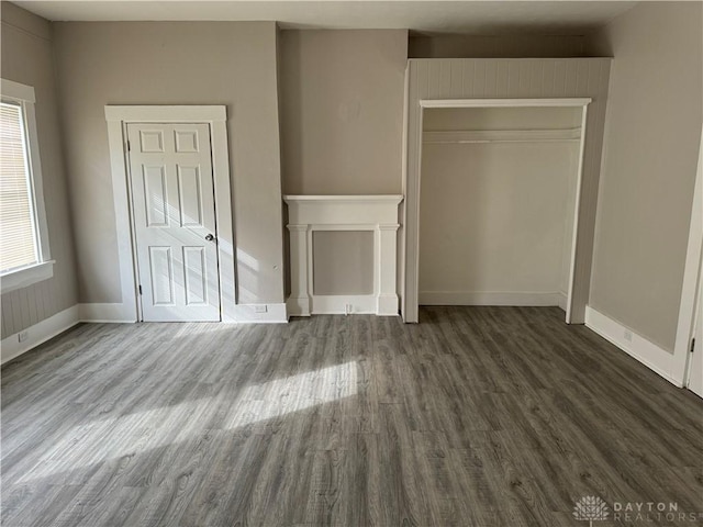 unfurnished living room with wood finished floors and baseboards