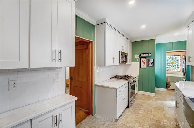 kitchen featuring white cabinetry, stainless steel appliances, and ornamental molding