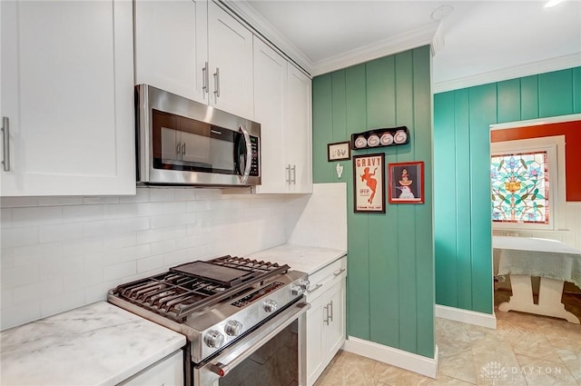 kitchen with backsplash, appliances with stainless steel finishes, white cabinetry, and crown molding