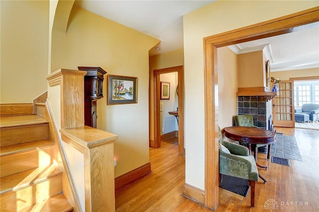 hallway with visible vents, baseboards, wood finished floors, and stairway