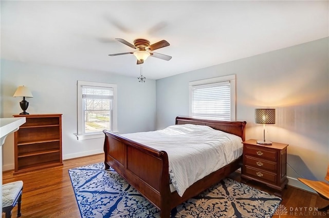 bedroom with a ceiling fan, baseboards, and wood finished floors