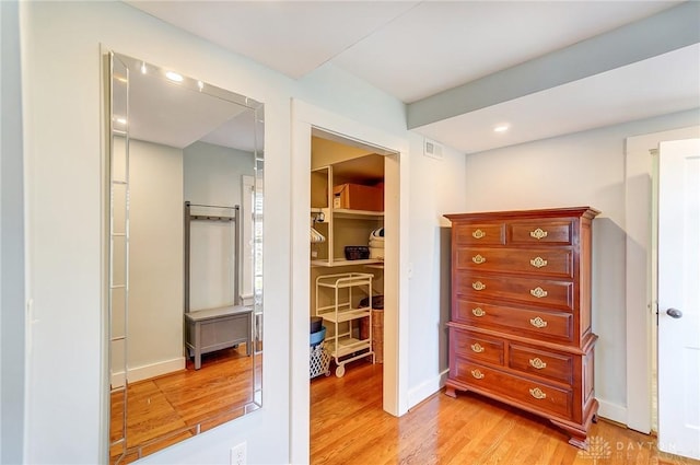 interior space with light wood finished floors, visible vents, and baseboards