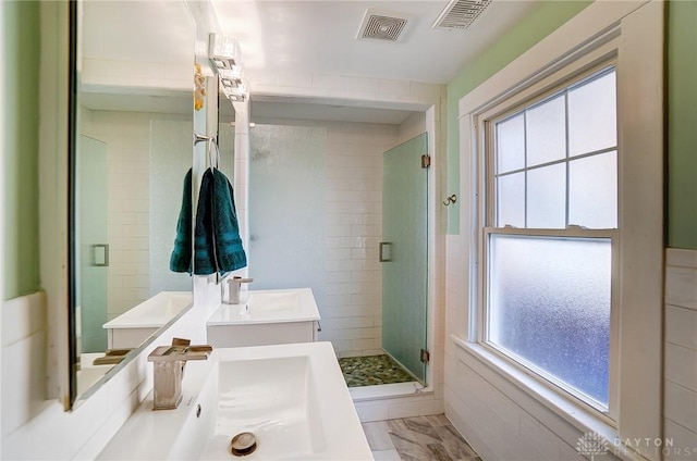 full bath with visible vents, a shower stall, and a sink