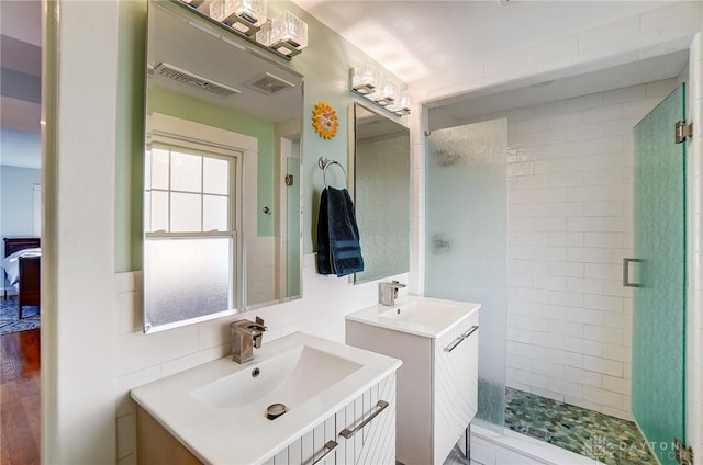 full bath with a stall shower, visible vents, and a sink