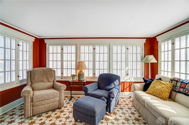 living area with baseboards and ornamental molding