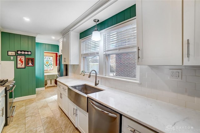 kitchen featuring ornamental molding, a sink, backsplash, stainless steel appliances, and white cabinets