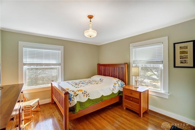 bedroom with baseboards and wood finished floors