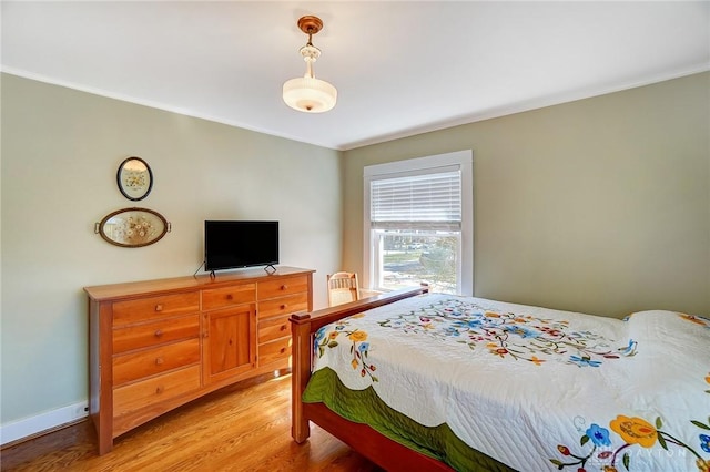 bedroom featuring baseboards, light wood-style floors, and ornamental molding