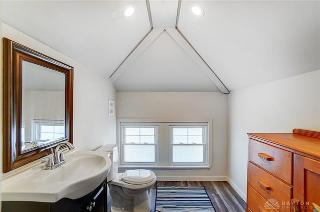 half bathroom featuring visible vents, toilet, vaulted ceiling, wood finished floors, and vanity