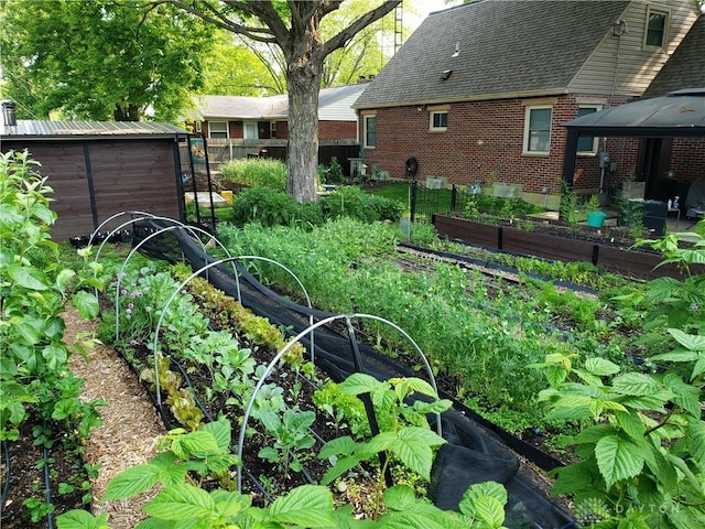 view of yard featuring a garden, a gazebo, an outdoor structure, and a storage shed