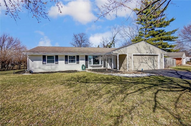 single story home with a front lawn, an attached garage, driveway, and fence