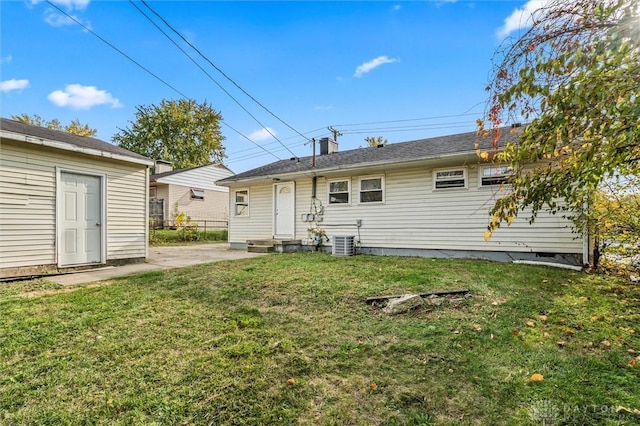 back of property featuring entry steps, a patio area, central air condition unit, and a lawn