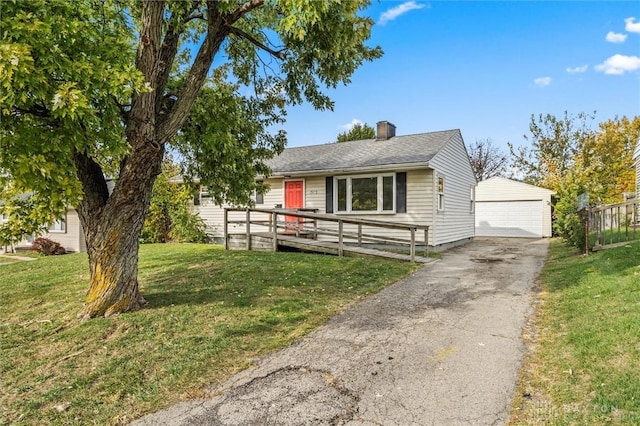 ranch-style home with a detached garage, a front lawn, a chimney, a deck, and an outbuilding