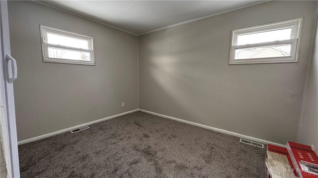 unfurnished room with visible vents, crown molding, baseboards, and carpet floors