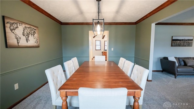 dining area featuring crown molding, carpet flooring, and baseboards