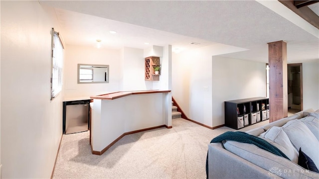 living area with baseboards, light carpet, and stairway