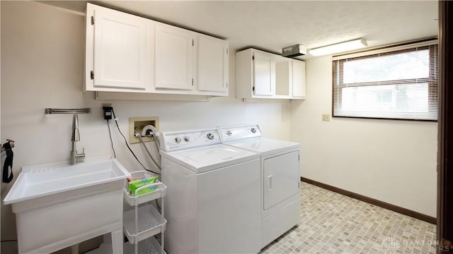 washroom with washer and dryer, cabinet space, baseboards, and a sink