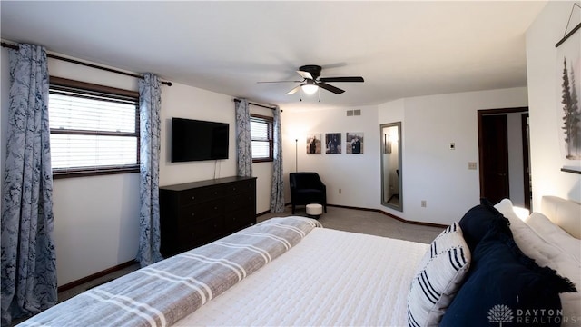 carpeted bedroom with visible vents, baseboards, and ceiling fan