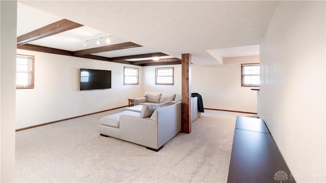 living room with baseboards, beam ceiling, a healthy amount of sunlight, and light carpet